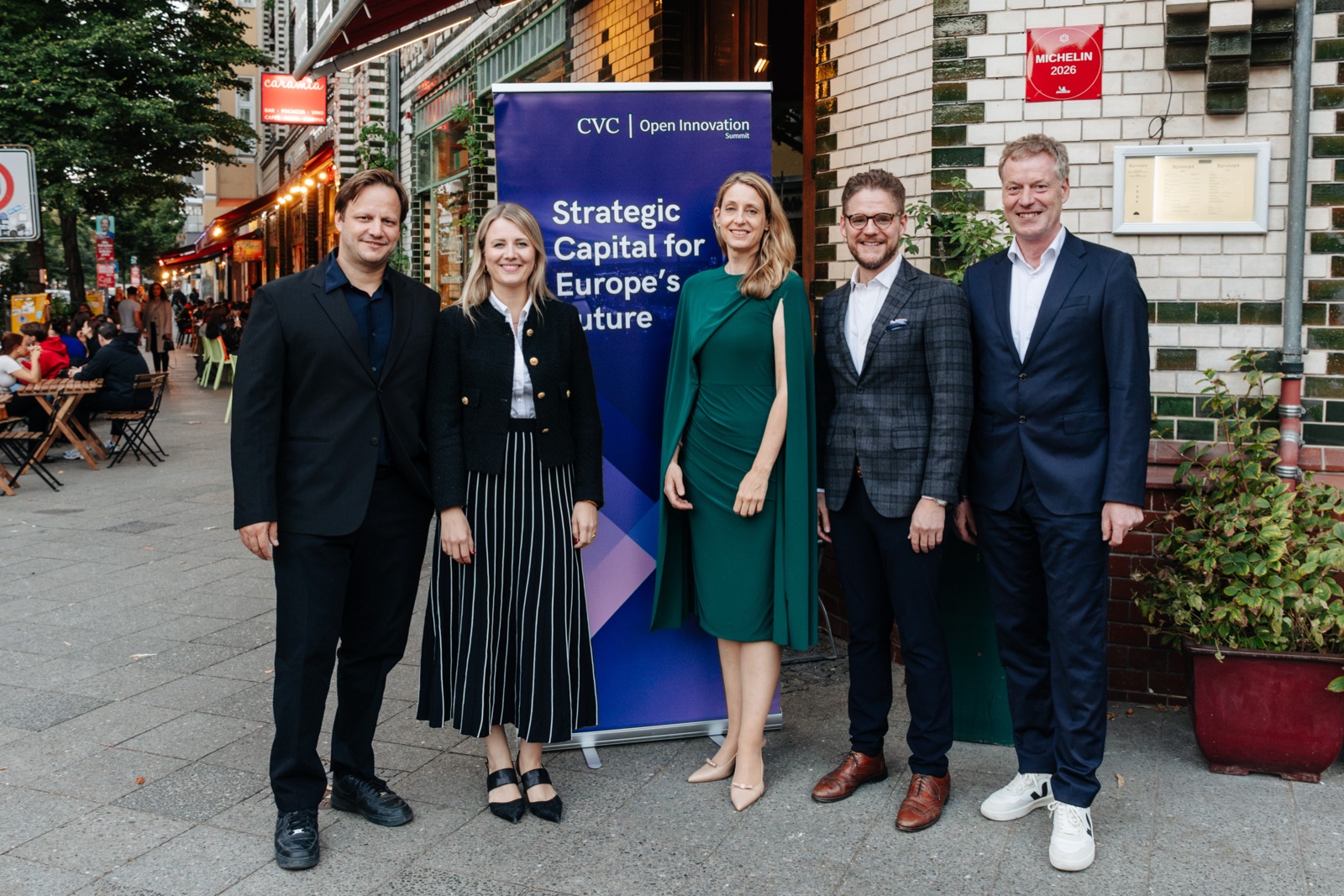 Five people in front of the summit banner in Berlin